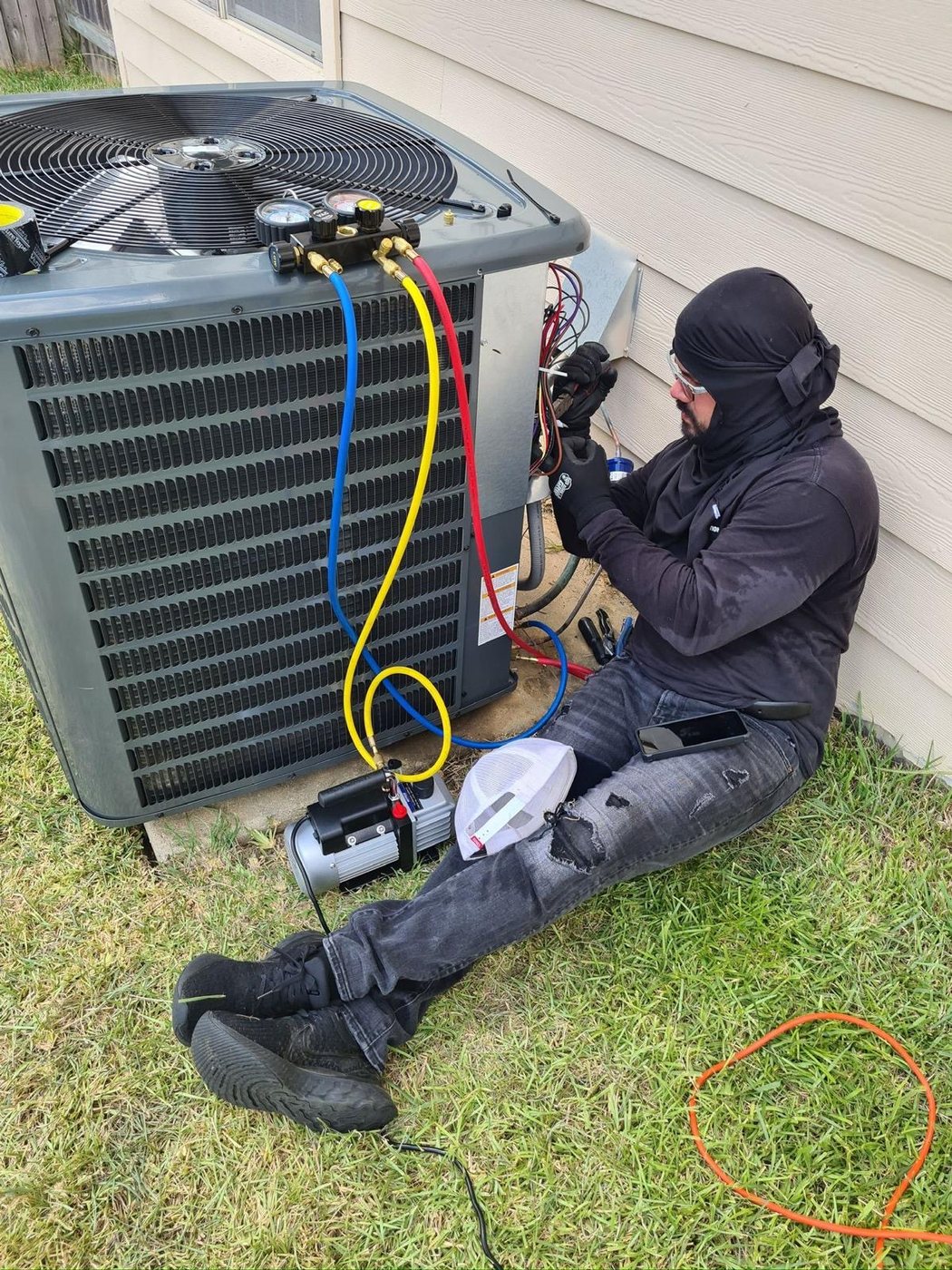 Elite Gonzalez Services HVAC technician servicing an outdoor AC system